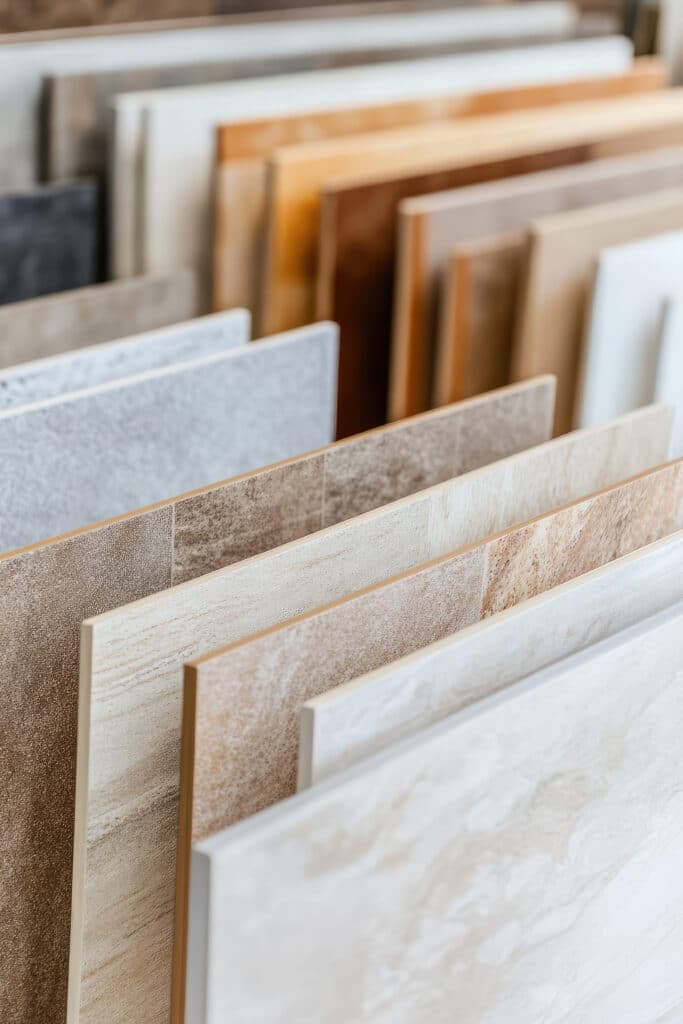 Échantillons de Carreaux de Sol et Mur - Textures Naturelles Échantillons de carreaux de céramique et de porcelaine aux textures variées, allant du gris chiné au beige marbré et bronze texturé.